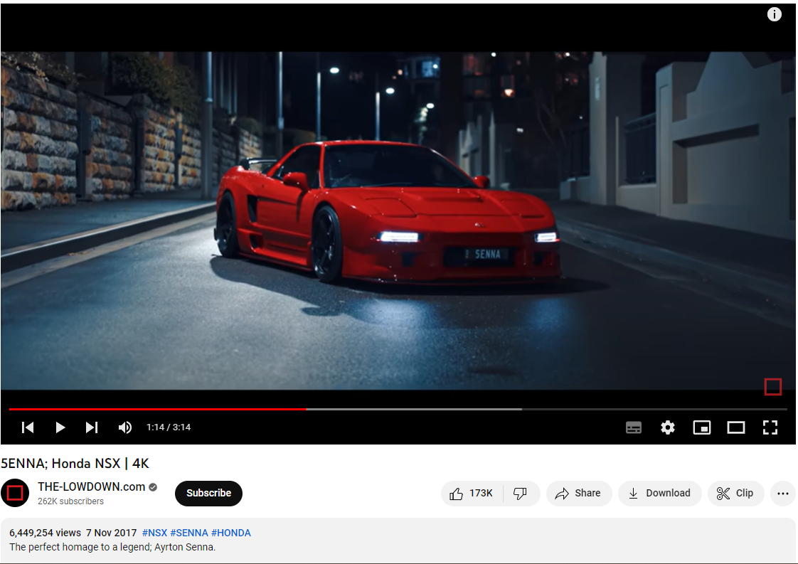 A vibrant red sports car, resembling a Honda NSX, parked on an urban street at night, illuminated by street lights and showcasing its sleek, aerodynamic design.